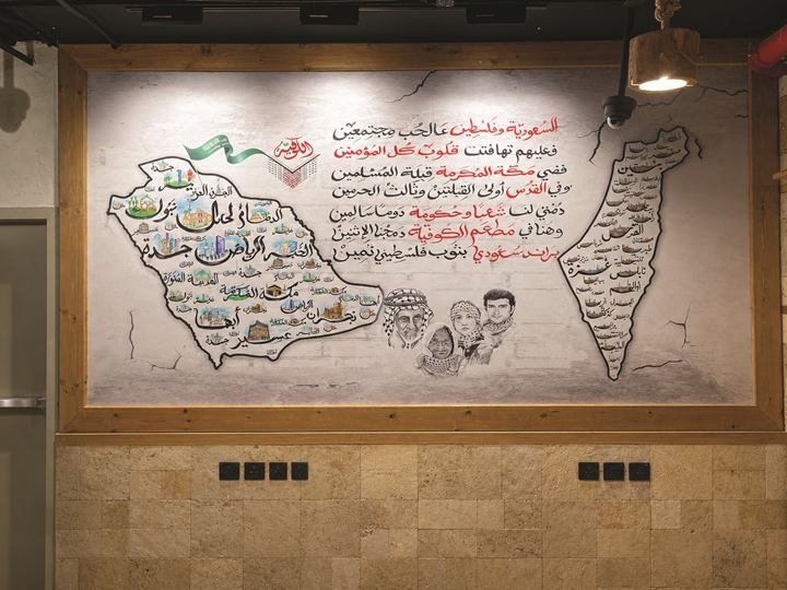 Restaurant wall with hand-illustrated maps, portraits and Arabic calligraphy in red and black, framed in wood