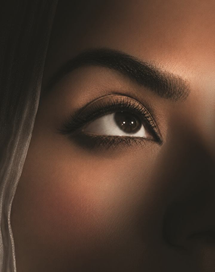 Close-up of an eye in warm light, from the SALLY NAJJAR company profile